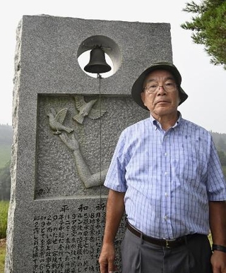 　太平洋戦争の終戦前後、宮崎県高千穂町の山中で起きた旧日本軍の戦闘機と米軍爆撃機が墜落した事故の平和祈念碑と工藤寛さん＝同町