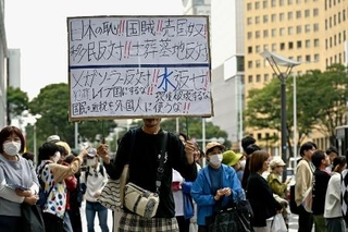 　宮城県知事選で、村井嘉浩氏の演説中に「日本の恥」などと記されたプラカードを掲げる人＝２０２５年１０月、仙台市