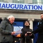 　１日、米ニューヨーク市庁舎で就任式に臨むマムダニ市長（右）と、妻のラマ・ドワジさん（中央）。左はサンダース上院議員（ゲッティ＝共同）