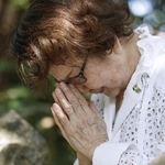 沖縄県糸満市にある戦没した医療従事者の碑に手を合わせる玉木利枝子さん＝２０２５年６月２２日