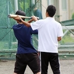 　顧問を務める野球部の朝練習で、生徒のフォームを指導する