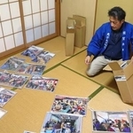 　過去に行われた「敦賀西町の綱引き」の写真を並べる寺田徹也さん＝２０２６年１月、福井県敦賀市