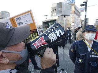 　埼玉県川口市長選の立候補予定者の街頭宣伝に抗議する男性（左）＝１月１８日、ＪＲ川口駅前