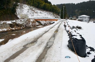 　２０２４年９月の豪雨で被災し、復旧に向けて土のうが積まれた河川の堤防＝１月２８日、石川県輪島市