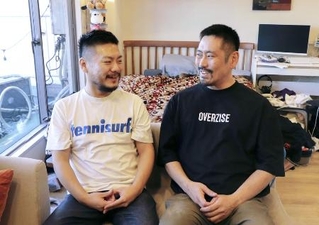 自宅で会話するザン・クリストファーさん（左）と鹿島真人さん＝２０２５年１１月、東京都内