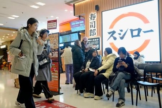 　北京市中心部のショッピングセンターにある、回転ずしの「スシロー」で入店を待つ人たち＝１月（共同）