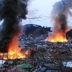 　津波の後、火災が発生した岩手県山田町の中心部＝２０１１年３月１１日午後５時４２分（同町提供）