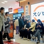 　北京市中心部のショッピングセンターにある、回転ずしの「スシロー」で入店を待つ人たち＝１月（共同）
