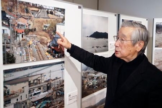 　撮りためた被災地の写真を紹介する「大船渡津波伝承会」の齊藤賢治さん＝２月、岩手県大船渡市