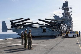 　米海軍の強襲揚陸艦トリポリの甲板に駐機する輸送機オスプレイと乗組員ら＝２月、フィリピン海上（米軍提供）