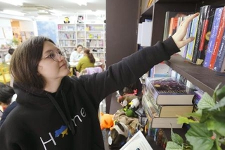 図書室で本を探すオルハ・コビリャンスカさん＝２月、東京・渋谷