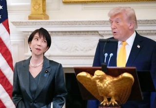 　ホワイトハウスで行われた夕食会で、あいさつするトランプ米大統領（右）を見る高市首相＝１９日、ワシントン（共同）