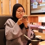 　回転すし屋で注文したラーメンの写真を撮るガヤトリさん＝２０２５年１１月、茨城県神栖市