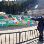 　校庭に立つ佐藤敏郎さん。壁画には「未来を拓く」と書かれている＝２月、宮城県石巻市の旧大川小