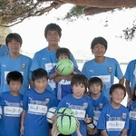 ２０１１年９月、岩手県陸前高田市の高田小を訪れ、子どもたちと写真に納まるサッカーＪ１川崎の選手たち。前列右から４人目が当時の村上力己選手。後列左から２人目が当時川崎のコーチだった寺田周平監督（☆（○の中に小文字のＣ）ＫＡＷＡＳＡＫＩ　ＦＲＯＮＴＡＬＥ）