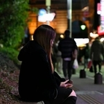 　かつて通った東京・歌舞伎町で植え込みに腰かける女性＝２月