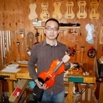 　工房でバイオリンを持つ池尻雅博さん＝２０２６年２月、愛知県一宮市