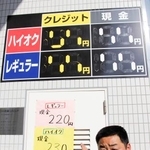 　ガソリンスタンド備え付けの看板では１９９円までしか表示できず、急きょ紙に手書きした価格を示す三枝直樹店長＝１６日午後、東京都足立区