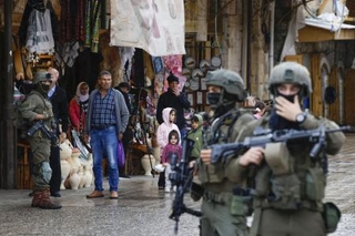 　パレスチナ自治区ヨルダン川西岸ヘブロンで、パレスチナ人を警戒するイスラエル軍兵士＝２０２５年１１月（共同）