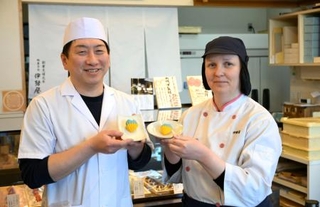 　ウクライナ国旗色の和菓子を持つ谷川イリーナさん（右）と上田浩人さん＝２０２６年３月、福井県小浜市