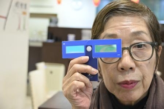 美術展で貸し出している補助レンズを手にするＮＰＯ法人「Ｔｒｕｅ　Ｃｏｌｏｒｓ」の高橋紀子代表＝２５年１２月、大阪市