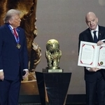 　サッカーＷ杯北中米３カ国大会の組み合わせ抽選会で、トランプ米大統領（左）の「平和賞」受賞を発表するＦＩＦＡのインファンティノ会長＝２０２５年１２月、米ワシントン（共同）