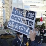 埼玉県川口市長選の立候補予定者の街頭宣伝に抗議し示されたプラカード＝１月１８日、ＪＲ川口駅前