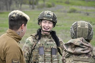 　談笑するナタリア・カメンスカヤさん（中央）＝２０２６年４月２７日、ウクライナ南部ザポリージャ州（共同）
