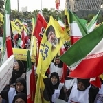 　１２日、イラン・テヘランで国旗などを手に広場に集まった人たち（ゲッティ＝共同）