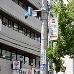 　ＪＲ日暮里駅前の電柱に設置された、顔を識別するＡＩを搭載した防犯カメラ（上）＝５月、東京都荒川区