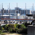 一戸建て住宅の向こうに見える阪神タイガース２軍球場。防球ネットを張る塔に囲まれている＝尼崎市