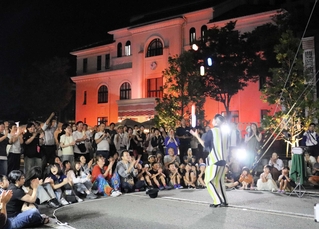 「豊岡演劇祭２０２５」で大道芸を楽しむ観客ら＝豊岡市中央町