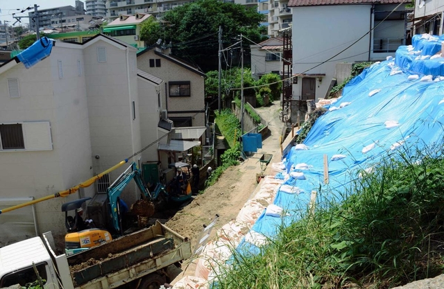 警戒区域外で起きた土砂崩れ。ブルーシートに覆われた斜面から、隣接する民家へ土砂が流れ込んだ＝７月２４日、神戸市長田区上池田３