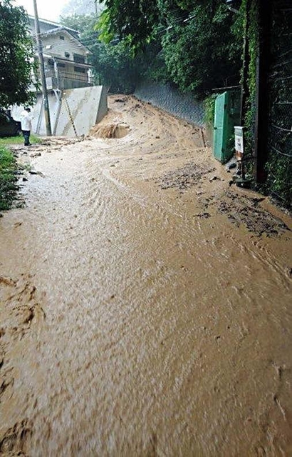 土石流が発生する前に道路を茶色い水が流れた＝６日午後３時３５分、神戸市灘区篠原台（住民提供）