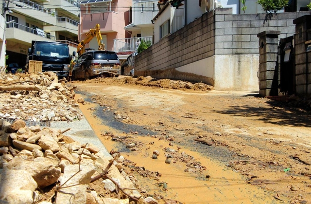 重機で土砂が取り除かれた道路。路肩には依然がれきが残っている＝１０日午前１０時３７分、神戸市灘区篠原台