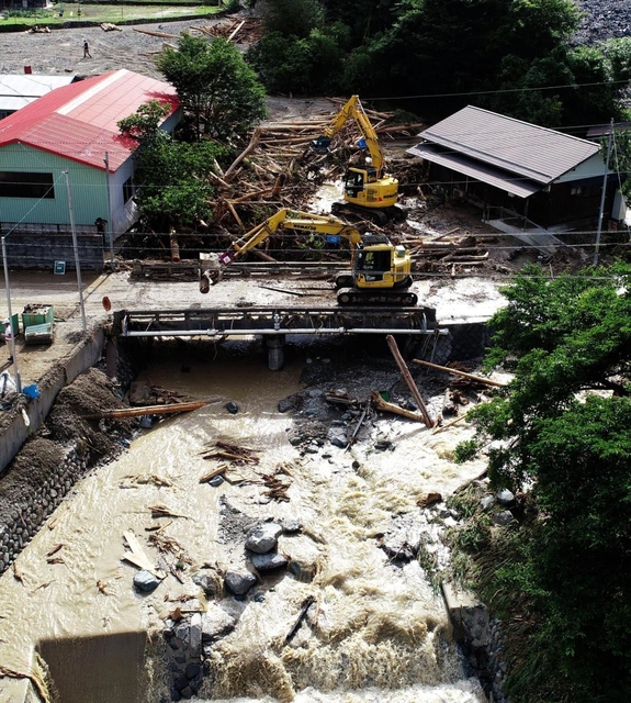 流木が川をせき止めたため、重機を使って進む撤去作業＝９日午後４時３６分、宍粟市一宮町河原田