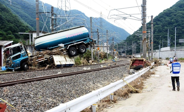 水に流されてＪＲ伯備線の線路上に押し上げられたタンク車＝１１日午後０時８分、岡山県高梁市松山