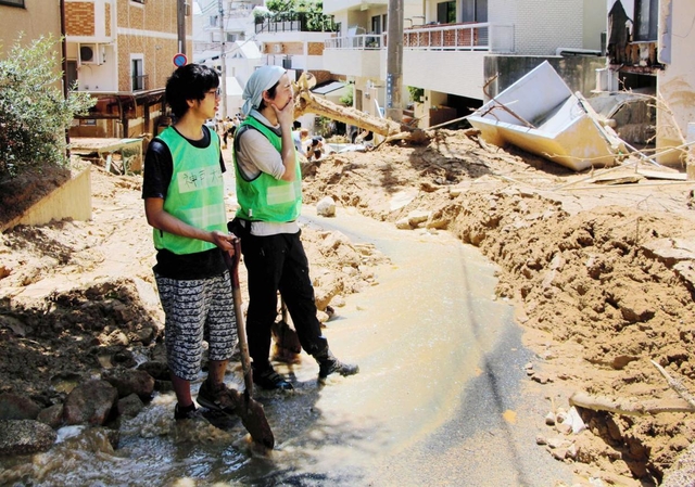「何から手を付ければいいのか」。大量の土砂を前に途方に暮れるボランティア学生＝１０日午前１１時４３分、神戸市灘区篠原台