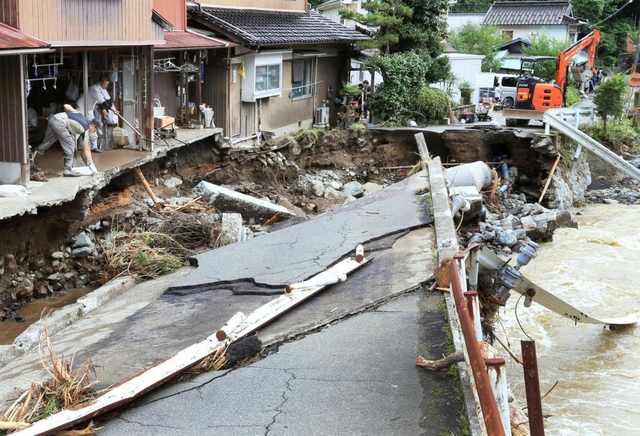 川の氾濫で破壊された道路。辛うじて残った民家でも、住民らが片付けに追われた＝８日午後２時４８分、宍粟市一宮町河原田（撮影・小林良多）