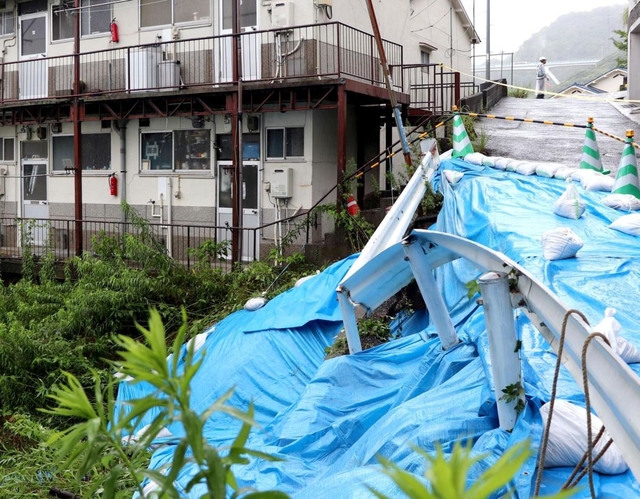 集合住宅横の道路が大雨で陥没した＝６日午前１０時４分、神戸市長田区檜川町３（撮影・吉田みなみ）