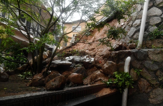 大雨の影響で崩れた住宅裏の土砂＝５日午後０時５５分、神戸市中央区中尾町