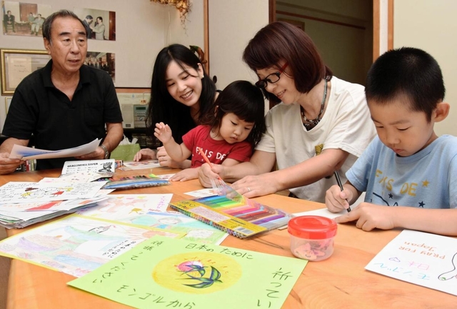 瓜谷幸孝さん（左端）らの呼び掛けに応じ、「元気メール」をしたためる子どもたち＝神戸市垂水区