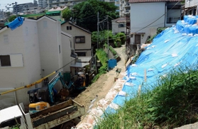 警戒区域外で起きた土砂崩れ。ブルーシートに覆われた斜面から、隣接する民家へ土砂が流れ込んだ＝７月２４日、神戸市長田区上池田３