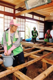 土砂を取り除いた後、床板の泥を落とすボランティアら＝１０日午後２時３８分、丹波市春日町山田（撮影・尾藤央一）