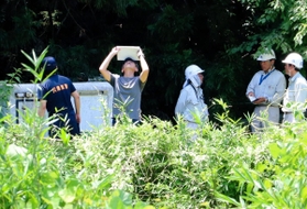 作業員が流された排水管の出口付近を調べる捜査員＝１０日午前１１時４８分、猪名川町差組