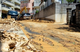重機で土砂が取り除かれた道路。路肩には依然がれきが残っている＝１０日午前１０時３７分、神戸市灘区篠原台