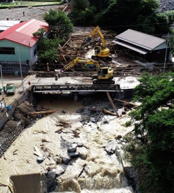 流木が川をせき止めたため、重機を使って進む撤去作業＝９日午後４時３６分、宍粟市一宮町河原田