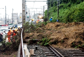 土砂で埋まった山陽塩屋－須磨浦公園間の線路。奥は立ち往生した山陽電鉄の特急電車＝６日午後、神戸市垂水区塩屋町１