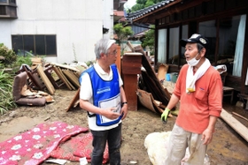 西日本豪雨で岡山県高梁市の川が氾濫し、川沿いの家屋が床上浸水の被害に遭った山口賢治さん（右）の話を聞くひょうごボランタリープラザの高橋守雄所長＝岡山県高梁市落合町阿部　