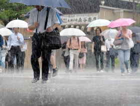 たたきつけるような雨の中、傘を差して歩く人たち＝５日午前、神戸市中央区